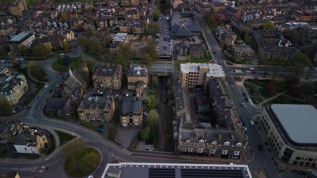 Birds eye view of public passenger train arriving into harrogate town through tunnel centre railway station at dusk