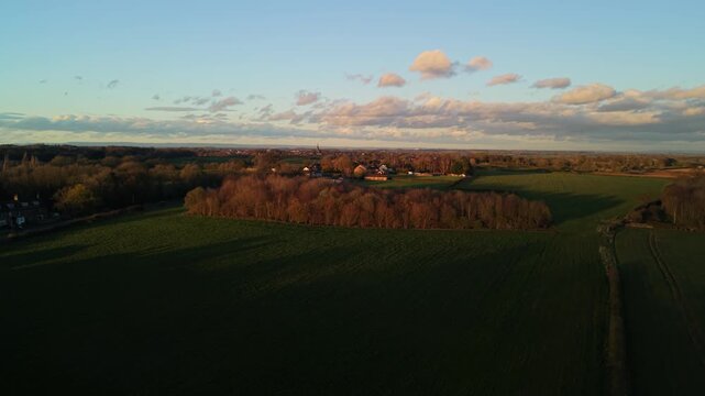 Soft dusk sunset light passes over farmers fields of Harrogate in North Yorkshire with soft colours and orange glow