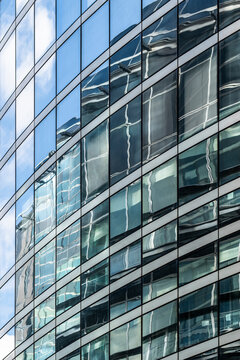 Abstract pattern on curved modern glass facade of office building windows showing architecture texture for corporate business background design