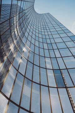 Curved modern skyscraper showing glass facade building windows and office architecture in dramatic perspective for corporate business backdrop