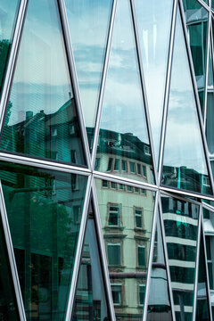 Curved urban office architecture with modern glass facade building windows and reflection forming corporate business abstract texture background