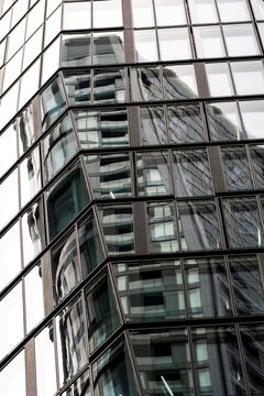 Office building corner with modern glass facade and windows reflection showing architecture perspective for corporate business abstract background