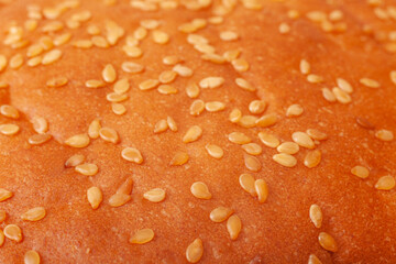 Macrofotografía de alimentos que resalta la frescura, los detalles, el atractivo visual y el sabor de los ingredientes clásicos de una hamburguesa. Primer plano de un pan de hamburguesa con sésamo © C.Castilla