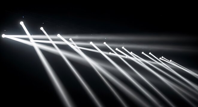 Diagonal white light beams cascade across a dark space, suggestive of a stage or performance