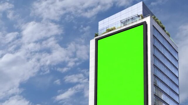 blank billboard oChroma Key Green screen vertical billboard on modern office building for advertising with bright sky and moving clouds background blue sky background