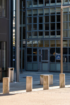 Modern minimal architecture facade with entrance bollards on empty street Oslo Norway creating quiet urban scene with security details and daylight