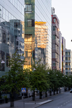Modern minimal glass reflections on empty urban street buildings Stockholm Sweden creating quiet city mood with strong lines and sunlight