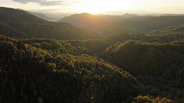 Cinematic aerial sunset over autumn mountains with sun flare and backlighting