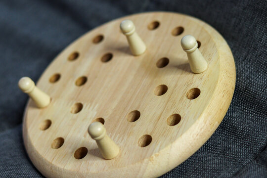 Wooden memory chess game puzzle board placed against a soft, textured fabric background.