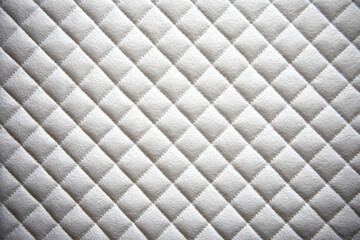 Naklejka premium White quilted fabric with a diagonal diamond pattern.