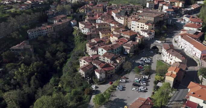 Aerial view of the historic stone houses and terracotta roofs of the village nestled in the green hills of Loro Ciuffenna, Tuscany, Italy.