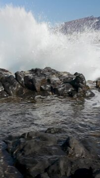 Panoramic view of foamy sea waves breaking on the rocky coast of Los Gigantes, Tenerife, Canary Islands, Spain