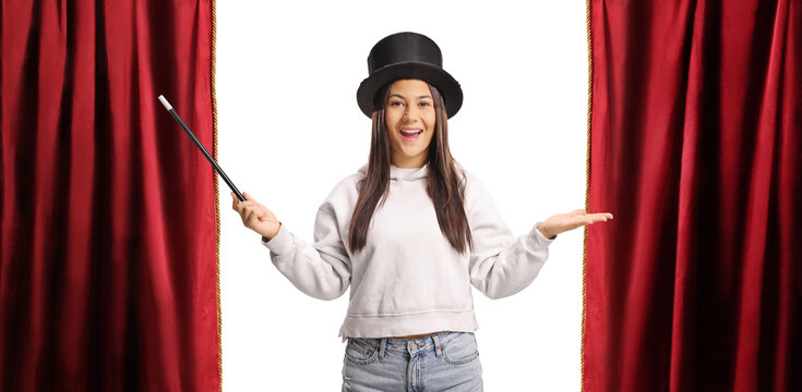 Girl wearing a magician top hat on stage with red curtains