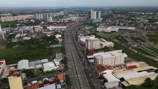 Aerial hyperlapse of busy traffic along a multi-lane highway road with mixed-use development at downtown Iloilo City, Visayas, Philippines