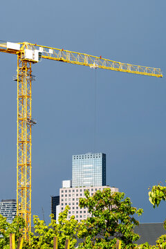 Frankfurt crane above urban construction shows city skyline with highrise development where architecture and engineering drive modern growth