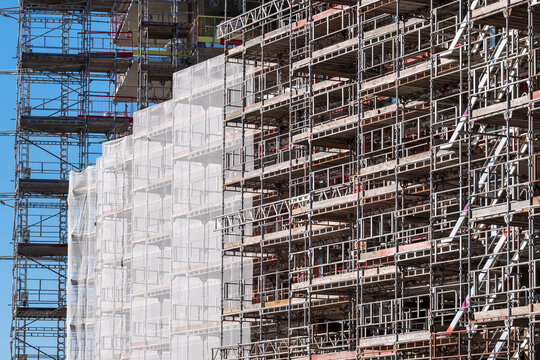 Oslo urban construction shows steel scaffolding and netting on a new building facade with strong structure and modern development in progress