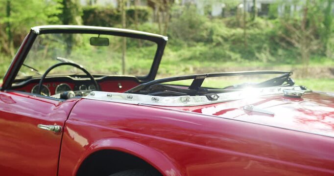 Close-up of a classic red convertible vintage car with chrome details and an open top