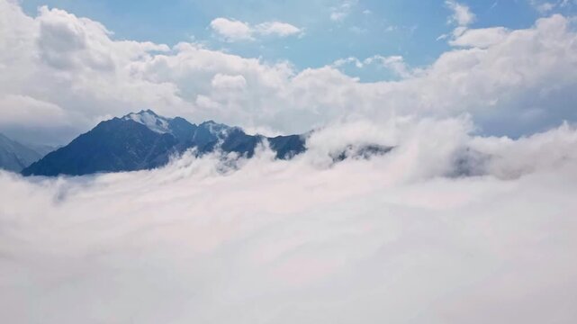 Timelipse High Altitude View Reveals Clouds And Towering Mountain Features Against Clear Horizon