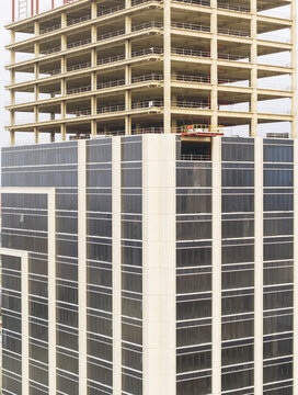 Aerial view of a modern skyscraper under construction with glass windows and exposed structural frame in Taoyuan, Taiwan.