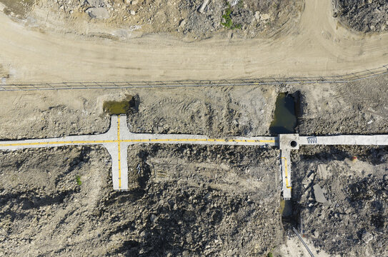 Aerial view of infrastructure of a new town with concrete foundations, yellow markings, and excavated earth New Taipei, New Taipei City, Taiwan.