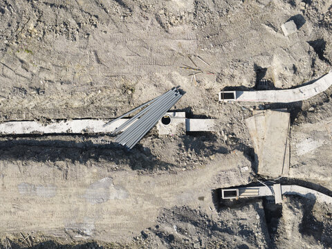 Aerial view of infrastructure of a new town with concrete trenches, pipes, and excavated earth at a construction site in New Taipei, New Taipei City, Taiwan.