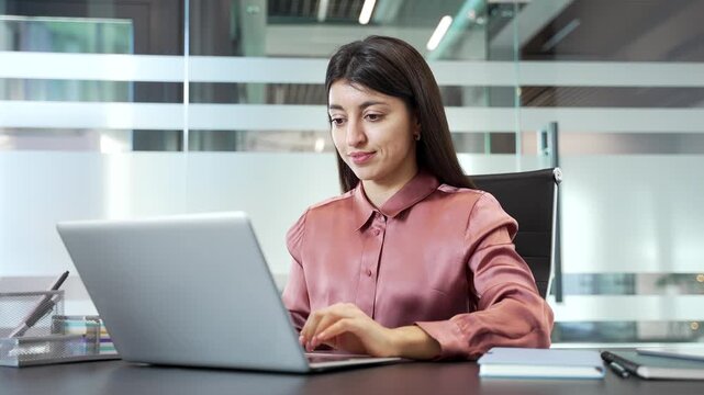 Happy businesswoman finished work on laptop in office, leaning back in chair with hands behind head. Satisfied female employee relaxing after completing tasks, expressing success, relief in workplace.