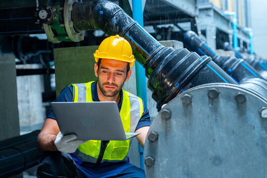 Industrial worker using laptop inspecting pipeline system in factory environment for maintenance and engineering operations technical inspection industrial monitoring troubleshoot process safety work