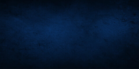 A dark blue grunge background with a vintage textured pattern featuring a rough old paper wall material and a dirty black chalkboard backdrop for a blank frame design © Mustarin