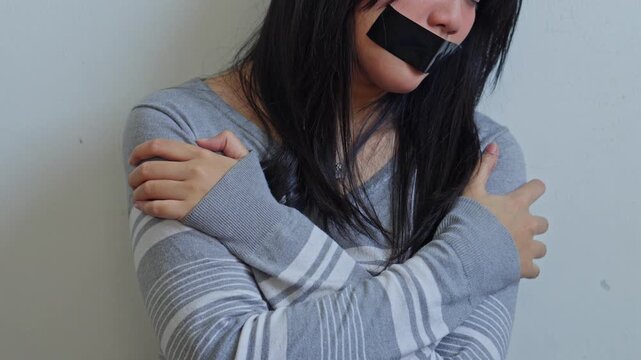 Close up of female victim with expressing fear and helplessness in minimalist setting