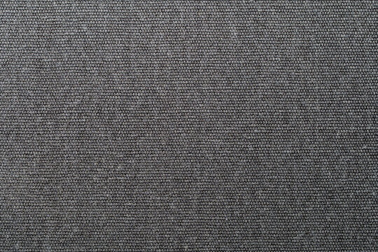 Closeup of painted fiberboard panel with rough textured surface dark finish ideal for background design furniture industry and construction material concept. Painted black fiberboard panel texture