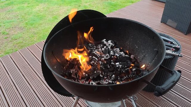 Lit barbecue charcoal on fire in preparation for cooking