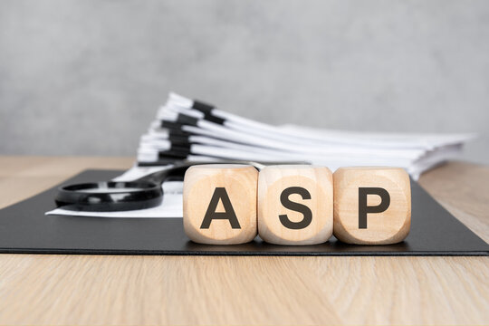 ASP acronym on wooden blocks. Blurred background with a document stack and magnifying glass. Business and finance concept.