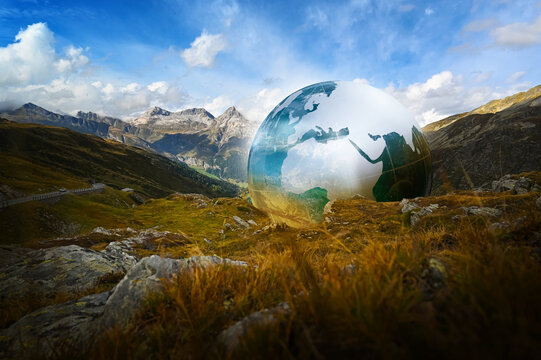 Environment, nature, a crystal globe ball in the mountains of Europe Spl&uuml;gen Pass Italy and Switzerland, Asia and Africa &ndash; sustainable environment and ecology, Earth, the world in 2026.