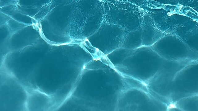 Water Surface Ripples: The serene image captures the mesmerizing dance of light and shadow on a water's surface, creating an abstract and tranquil visual experience.
