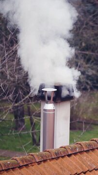 Smoking the whole neighbourhood from chimney burning wood in slow motion