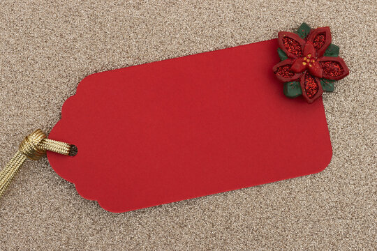 Red gift tag with poinsettia on gold glitter