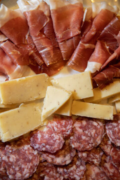 piatto con antipasti, formaggi e salumi affettati, piatto con fette di prosciutto crudo, salame e formaggio, cibo tradizionale italiano