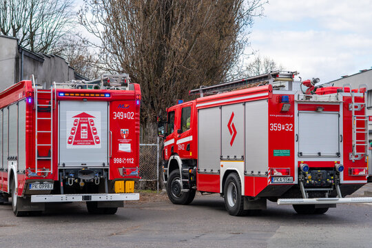 Two modern red fire engines parked side by side, side view of rescue firefighting trucks, professional fire department fleet in Poland, emergency vehicles with 998 and 112 emergency numbers and silver