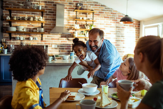 Happy family enjoying playful breakfast in home kitchen