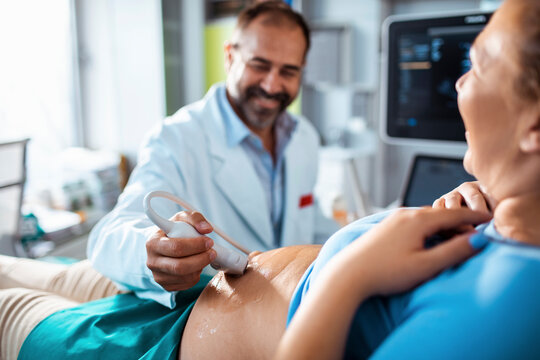 Doctor performing prenatal ultrasound on pregnant woman in clinic