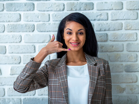 Businesswoman making call gesture.