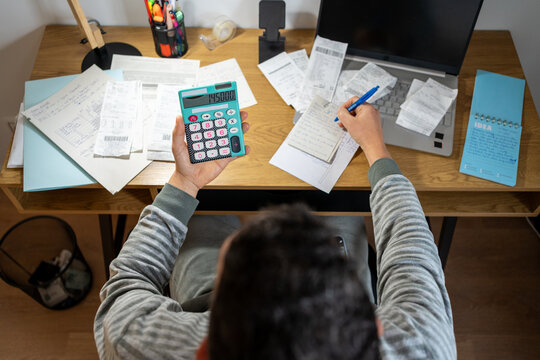 Entrepreneur calculating business finances at home office desk