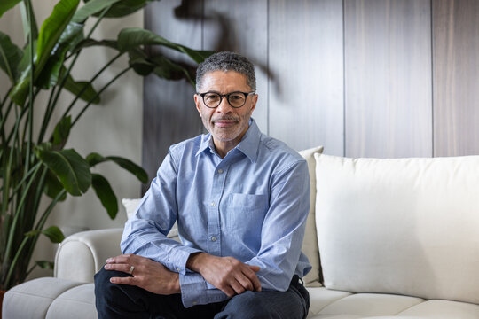 Confident mature man posing Thoughtfully on a Modern Sofa
