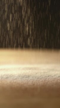 Slow motion video of flour falling on a wooden table