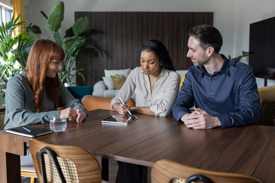 Couple signing a contract together with a personal advisor