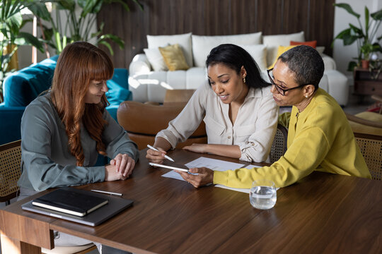 Three business women discussing plans in office setting