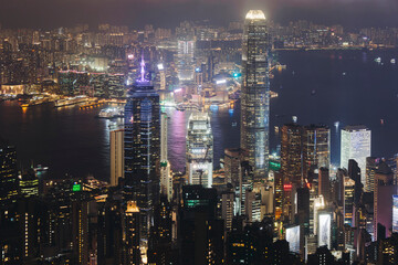 Obraz premium Hong Kong night evening view, China, seen from Victoria Peak observation deck, Lugard road lookout, with Hong Kong downtown skyscrapers and Kowloon island, illuminated city and Victoria Bay at night