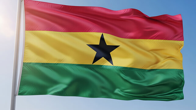 Waving flag of ghana against a clear blue sky with west africa, black star