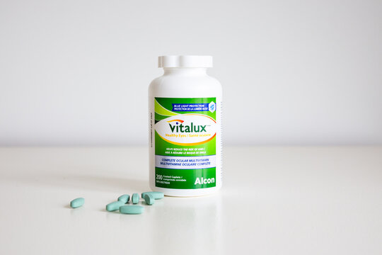 
Quebec City, Quebec, Canada, April 16, 2026 - Ocular multivitamin Vitalux in large 200 caplets bottle set on white background, with a few pills scattered on table


