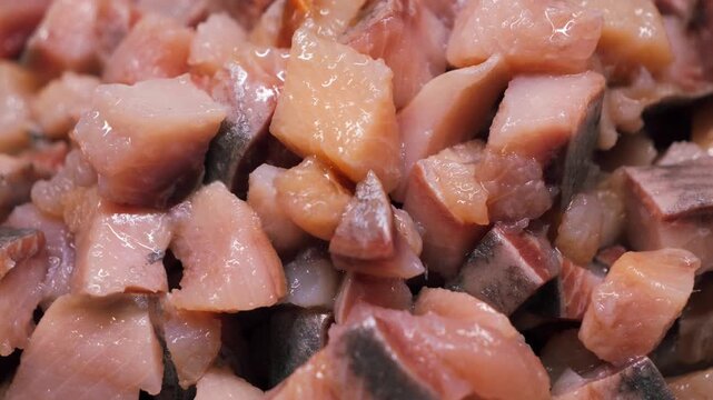 A close-up of diced salted herring, a cooked seafood dish. Food preparation concept, a traditional canned fish ingredient. High quality 4k footage